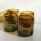 Four amber chunky handblown tumblers on a white surface