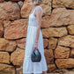 Girl walking with a mini woven basket bag in black