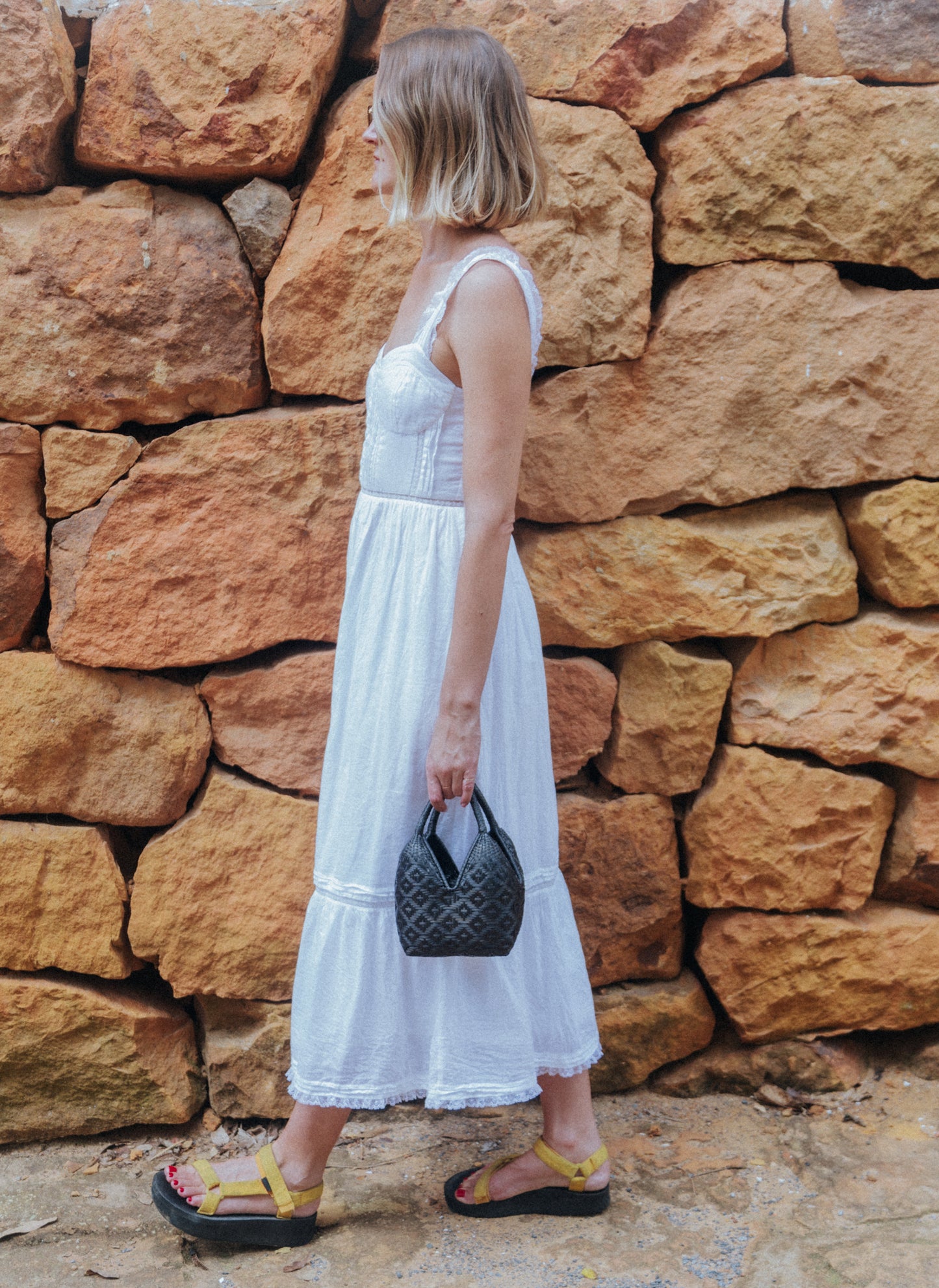 Girl walking with a mini woven basket bag in black