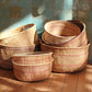 Set of handwoven baskets on a wooden floor with a tiled wall background