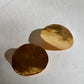 Two handmade gold disc earrings on a white background